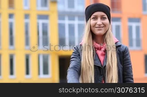 Attractive smiling woman catching keys of her new house and giving thumbs up
