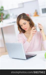 attractive smiling woman looking at computer at home