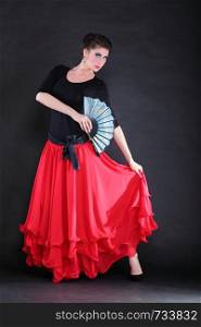 Attractive spanish dancer over black background young woman dancing flamenco