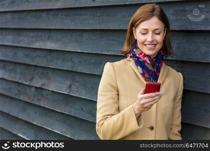 Attractive, successful and happy middle aged woman female using mobile cell phone for texting or social media. Middle Aged Woman Using Mobile Cell Phone