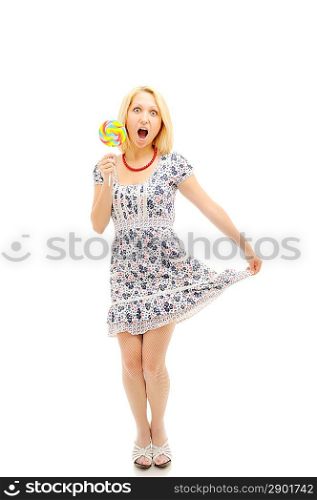 Attractive surprised blonde with lollipop holding her dress, looking like a littile girl