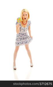 Attractive surprised blonde with lollipop holding her dress, looking like a littile girl