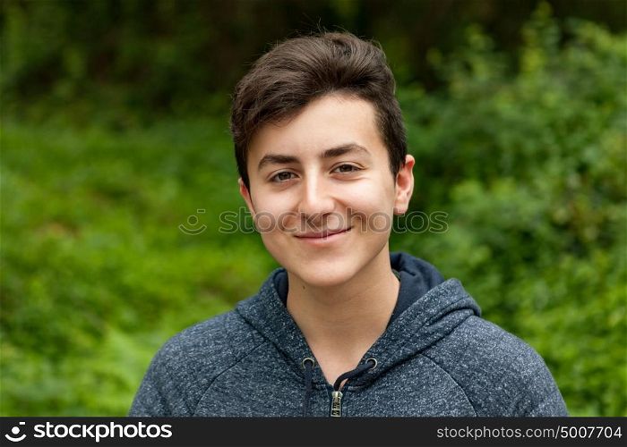 Attractive teenager guy in a park with green plants of background