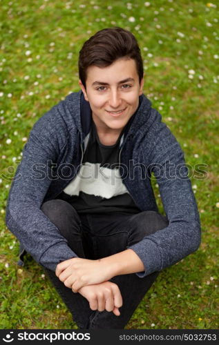 Attractive teenager guy in a park with green plants of background