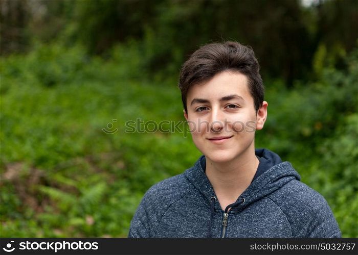 Attractive teenager guy in a park with green plants of background