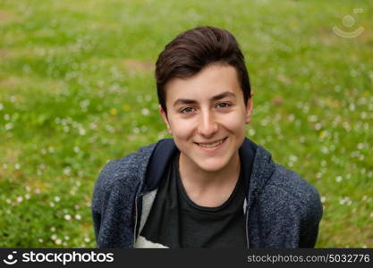 Attractive teenager guy in a park with green plants of background