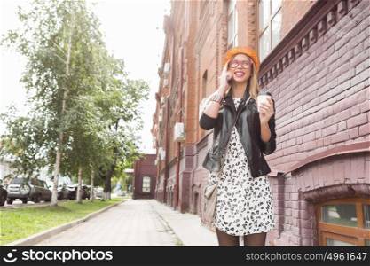 Attractive tourist see city . Young pretty girl tourist walking on street and talking on mobile phone