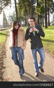 Attractive Urban Couple Walking Together In A City Park
