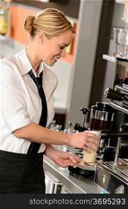 Attractive waitress making coffee with machine in bar