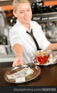 Attractive waitress taking tip in bar from tray american dollar