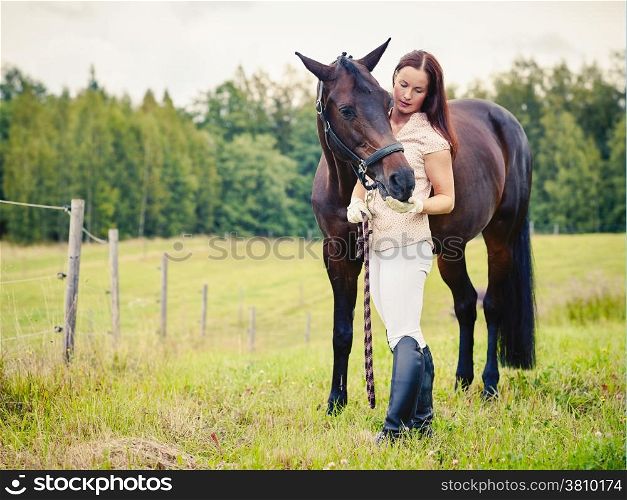 Attractive woman and horse in the field, cross processed image