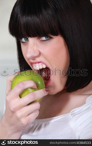 Attractive woman biting into a crisp green apple