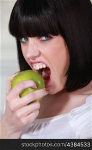Attractive woman biting into a crisp green apple