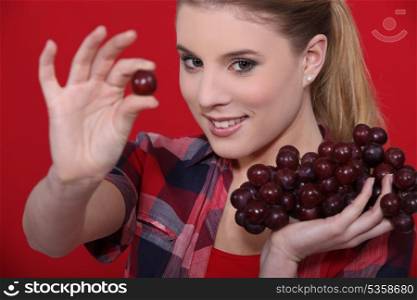 Attractive woman eating grapes