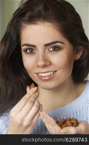 Attractive Woman Eating Handful Of Almonds