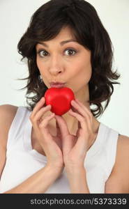 Attractive woman holding a small red heart