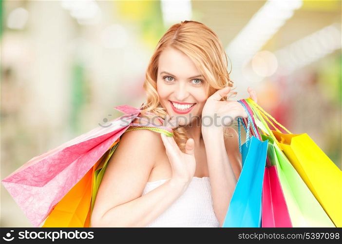 attractive woman holding color shopping bags in mall
