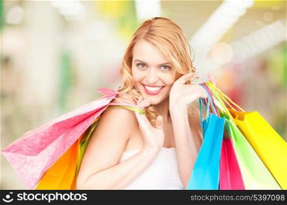 attractive woman holding color shopping bags in mall