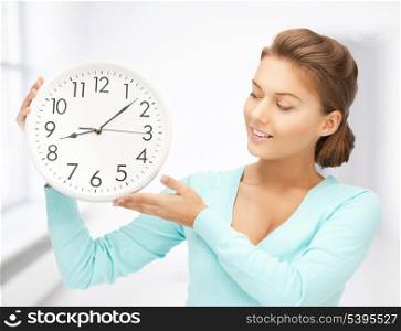 attractive woman holding wall clock in her hands