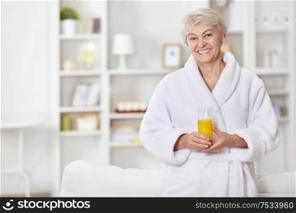 Attractive woman in a bathrobe with a glass of juice