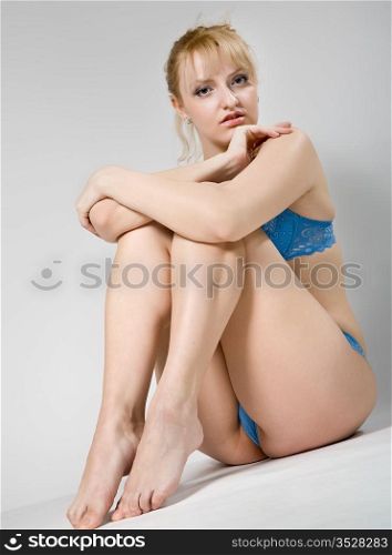 attractive woman in blue lingerie sitting on the floor