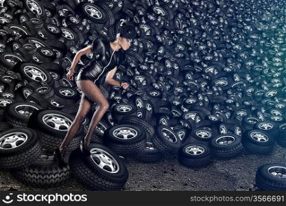 Attractive woman in dress running on tires