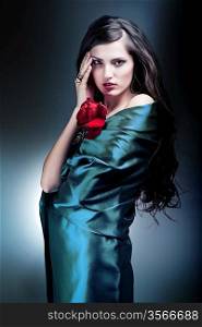 attractive woman in green fabric with red rose