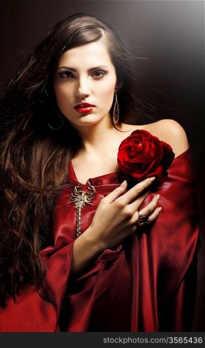 attractive woman in red drapery with red rose