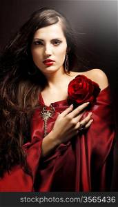 attractive woman in red drapery with red rose
