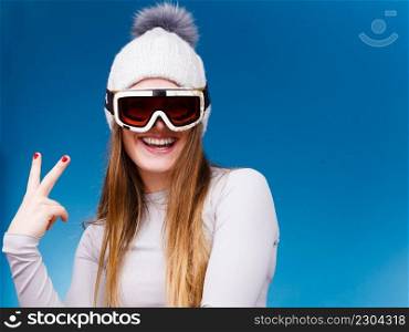 Attractive woman in winter cap gray sports thermal underwear for skiing training ski googles studio shot on blue. . woman in thermal underwear ski googles 
