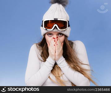 Attractive woman in winter cap gray sports thermal underwear for skiing training ski googles studio shot on blue. . woman in thermal underwear ski googles