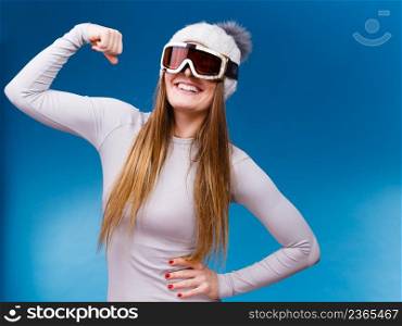 Attractive woman in winter cap gray sports thermal underwear for skiing training ski googles studio shot on blue. . woman in thermal underwear ski googles