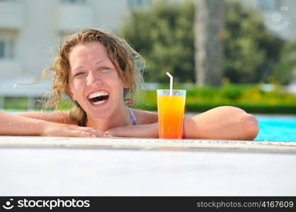 attractive woman is smiling from swimming pool in resort