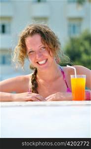 attractive woman is smiling from swimming pool in resort