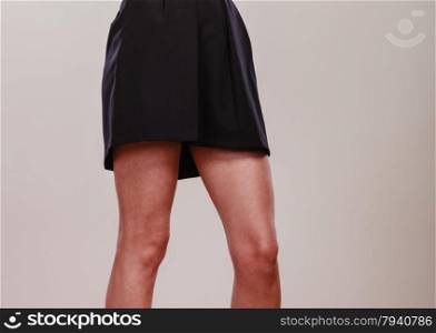 Attractive woman legs black skirt on gray