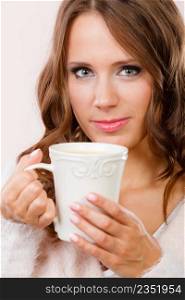 Attractive woman long hair holding white mug with coffee warm beverage. Woman warming herself