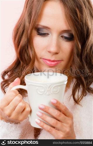 Attractive woman long hair holding white mug with coffee warm beverage. Woman warming herself