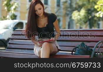 Attractive Woman Looking Photos on Digital Tablet Outdoors