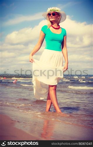 Attractive woman on the beach.. Summer time relax leisure concept. Attractive woman on the beach. Lady wearing sunglasses and hat