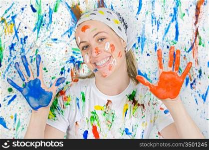 Attractive woman painting the background of many colors