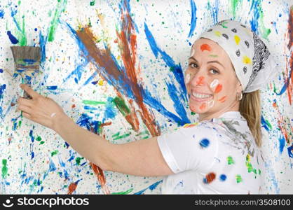 Attractive woman painting the background of many colors