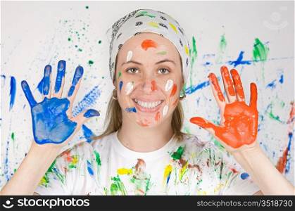 Attractive woman painting the background of many colors