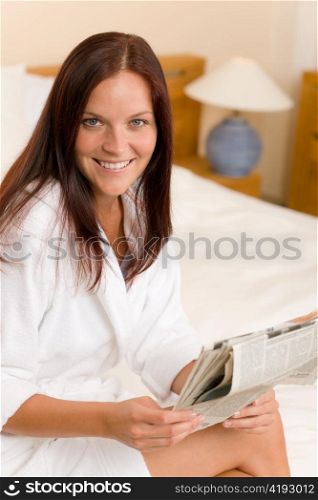 Attractive woman reading morning newspapers in bedroom wear bathrobe
