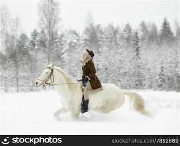 Attractive woman riding a white horse, winter landscape