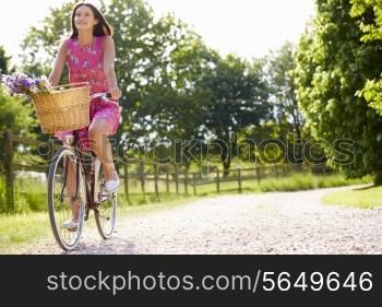 Attractive Woman Riding Bike Along Country Lane
