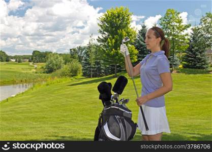 Attractive woman selects her golf club