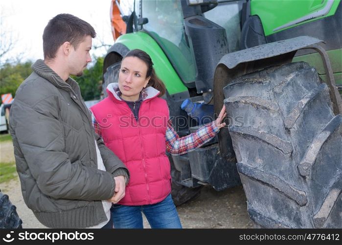 attractive woman selling brand new tractor to beginner farmer