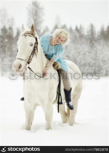 Attractive woman wearing blue dress and she riding a white horse