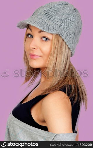 Attractive woman with a grey wool bonnet isolated on pink background