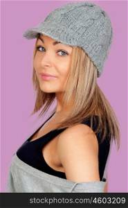 Attractive woman with a grey wool bonnet isolated on pink background